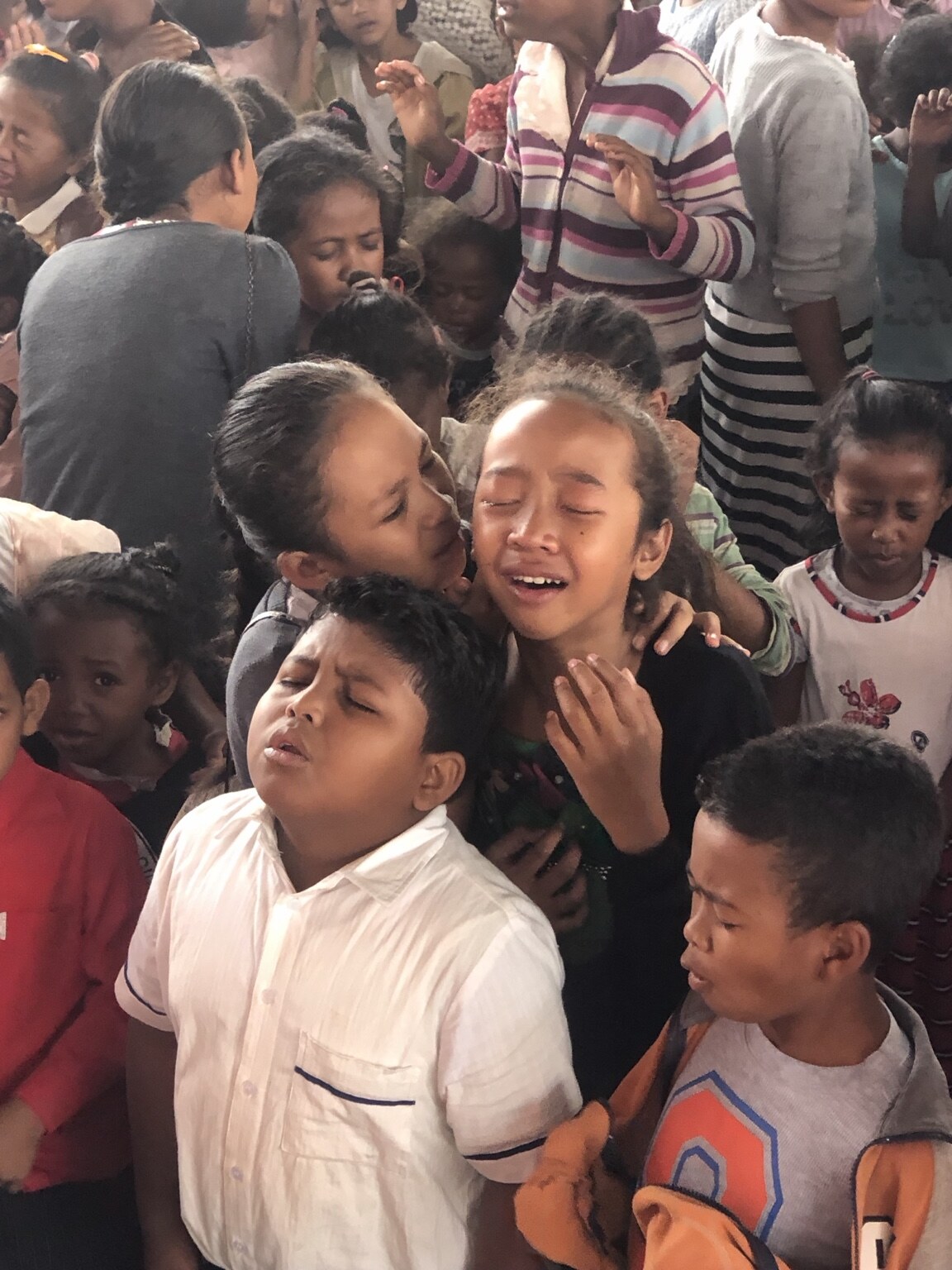 Children praying together during a ministry gathering in Madagascar