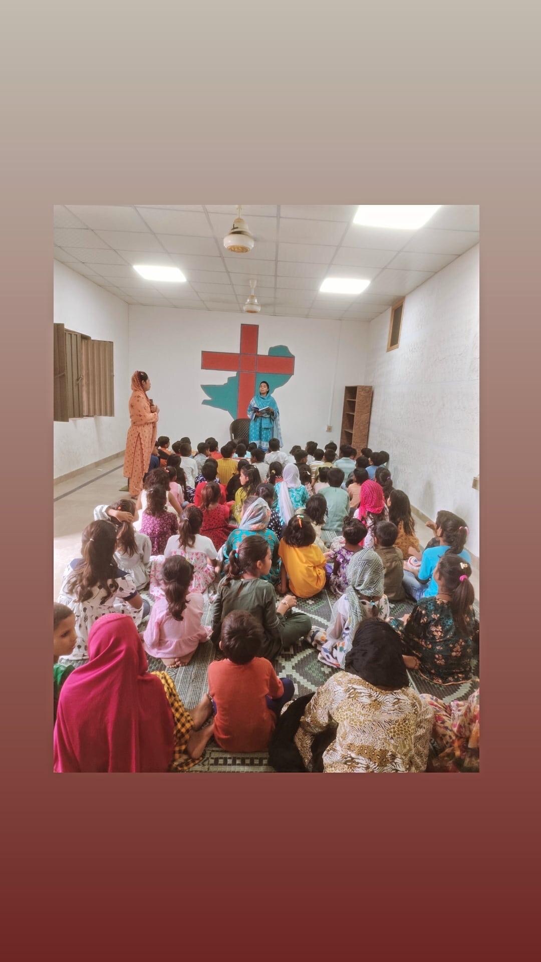 Children seated for a teaching gathering in Pakistan